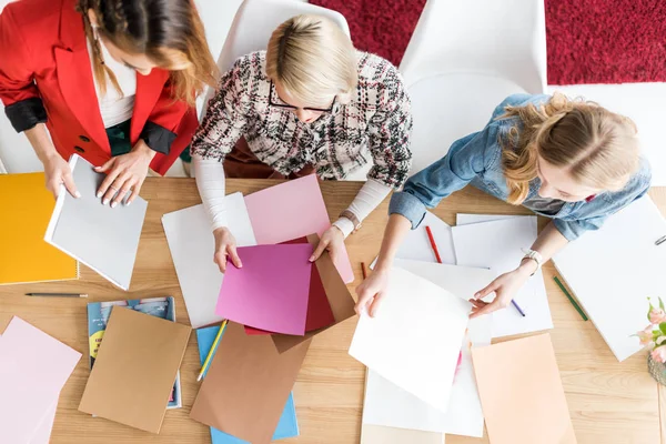 Overhead view of fashionable magazine editors working with color palette in modern office — Stock Photo