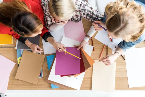 Overhead view of fashionable magazine editors working with color palette in modern office — Stock Photo