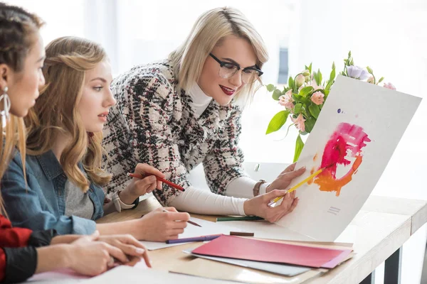 Fashionable magazine editors working with sketches in modern office — Stock Photo