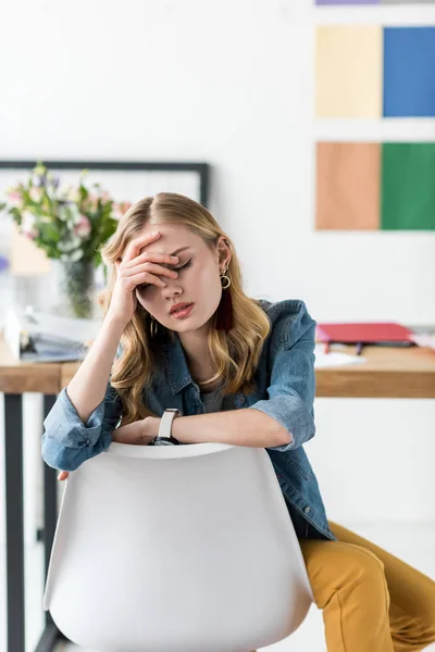 Erschöpfter Magazin-Redakteur sitzt am Arbeitsplatz in modernem Büro — Stockfoto