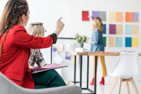 Magazin-Redakteurin zeigt auf Farbpalette im modernen Büro — Stockfoto