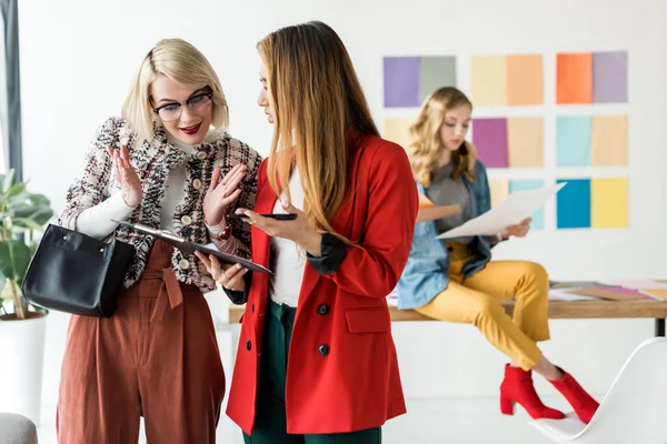 Multiethnic magazine editors working with documents on clipboard in modern office — Stock Photo