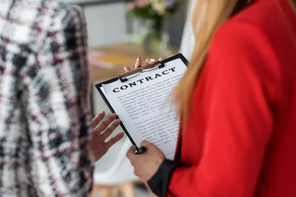 Vue recadrée des femmes d'affaires magazine travaillant avec contrat — Photo de stock