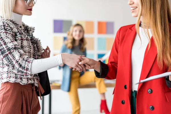 Modische Magazinredakteure beim Händeschütteln im modernen Büro — Stockfoto