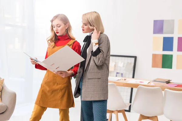 Fashionable magazine editors working with documents in folder in modern office — Stock Photo