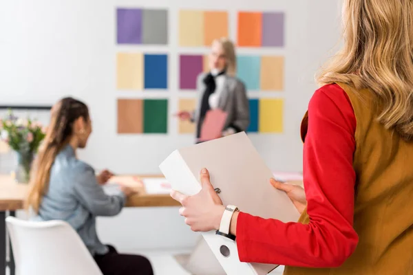 Magazinredakteurin mit Ordner und Kollegen im modernen Büro — Stockfoto