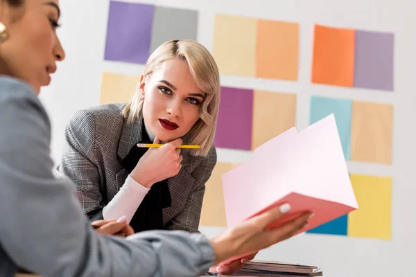 Éditeurs de magazines multiethniques à la mode travaillant dans un bureau moderne — Photo de stock