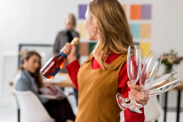 Magazine editors celebrating triumph with champagne in modern office — Stock Photo