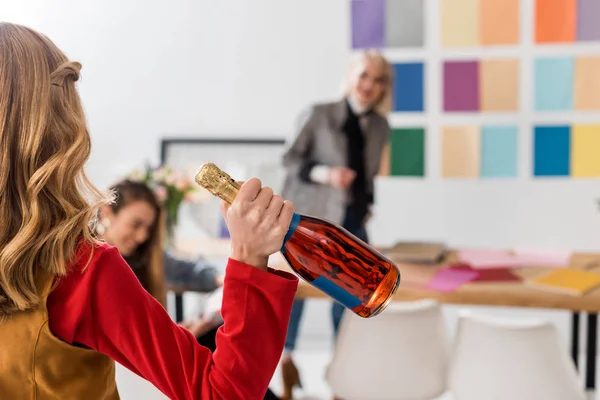 Selective focus of magazine editors celebrating with champagne in modern office — Stock Photo