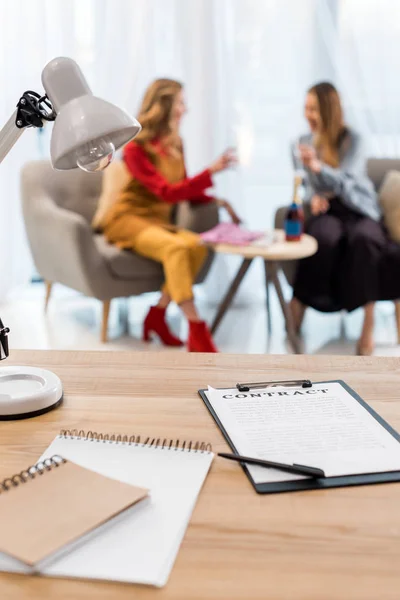 Selektiver Fokus von Geschäftsfrauen, die in modernen Büros arbeiten, Verträge und Dokumente auf dem Tisch im Vordergrund — Stockfoto