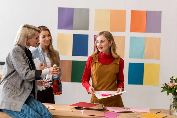 Éditeurs de magazines à succès célébrant avec du champagne dans un bureau moderne avec palette de couleurs — Photo de stock