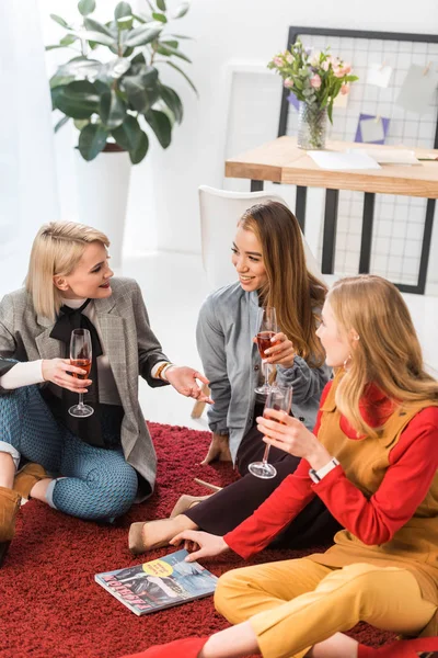 Successful magazine editors celebrating with champagne and talking about new magazine — Stock Photo