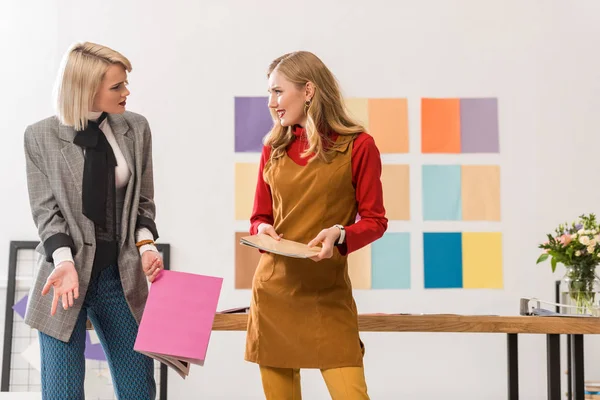 Editores de revistas da moda trabalhando no escritório moderno com paleta de cores na parede — Stock Photo