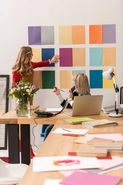 Modische Zeitschriftenredakteure arbeiten mit Farbpalette im modernen Büro — Stockfoto