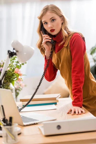 Stilvolle Geschäftsfrau telefoniert am Arbeitsplatz mit Laptop und Dokumenten — Stockfoto