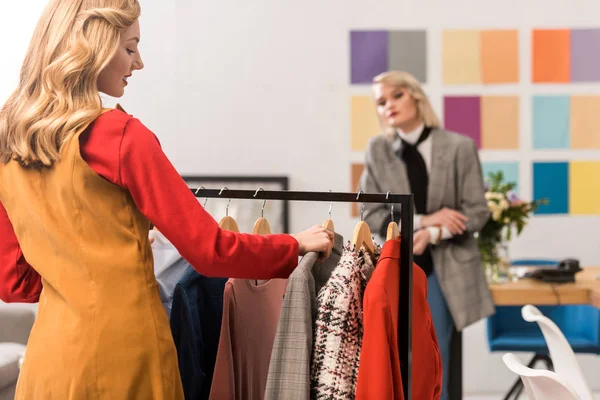 Designers de mode travaillant avec des vêtements dans le bureau moderne — Photo de stock