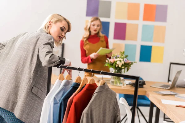 Éditeurs de magazines à la mode travaillant avec des vêtements dans le bureau moderne — Photo de stock