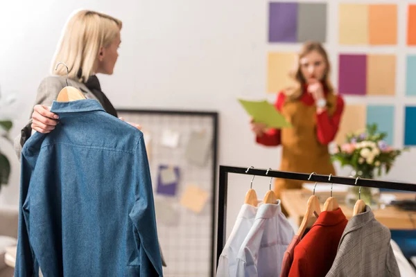 Modische Zeitschriftenredakteure arbeiten mit Kleidung im modernen Büro — Stockfoto