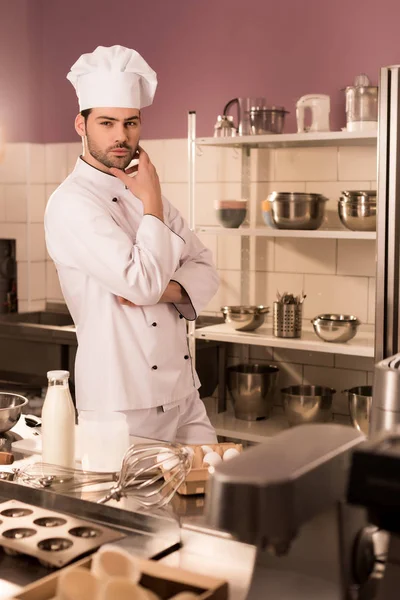 Confiseur coûteux debout au comptoir dans la cuisine du restaurant — Photo de stock