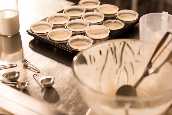 Vista de cerca de las formas de hornear con masa cruda para cupcakes - foto de stock