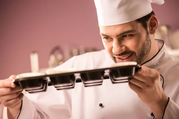 Pastelero comprobar la masa en forma de hornear en la cocina del restaurante - foto de stock