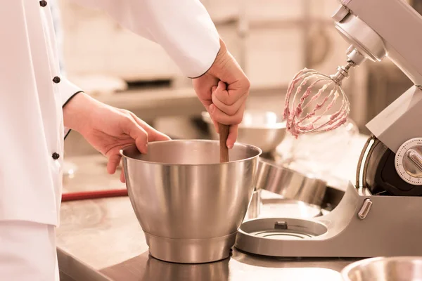 Partial view of confectioner making cream for dessert in restaurant kitchen — Stock Photo