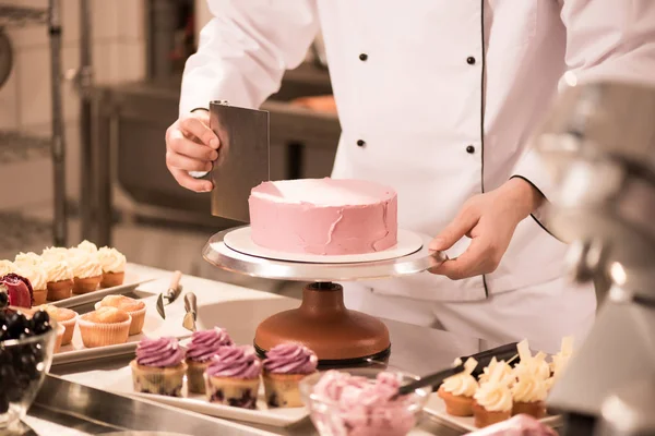 Cropped shot of confectioner making cake in restaurant kitchen — Stock Photo