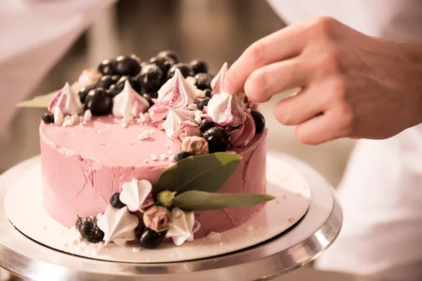 Vista parcial del confitero decorando pastel dulce - foto de stock