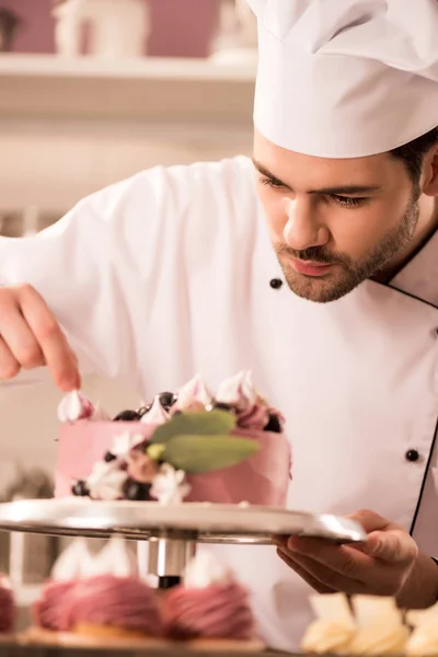 Portrait of confectioner decorating cake in restaurant kitchen — Stock Photo