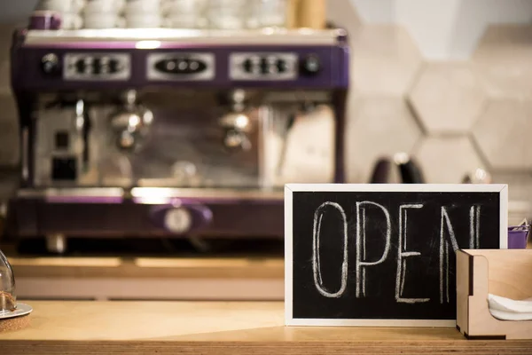 Selective focus of open blackboard on wooden counter in cafe — Stock Photo