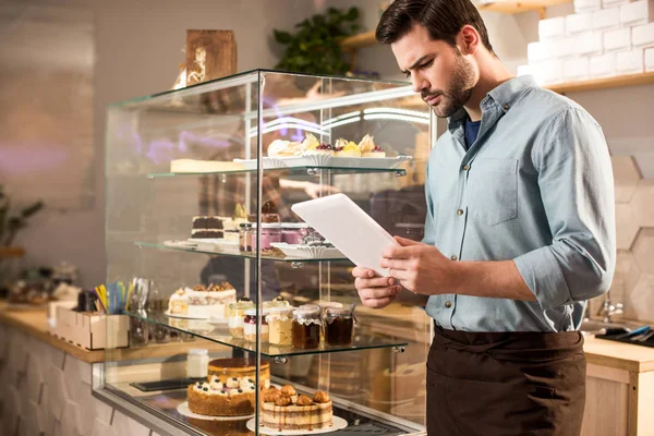 Side view of barista using tablet at work in coffee shop — Stock Photo