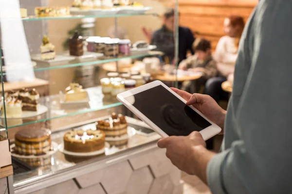 Vista parcial de barista usando tableta en el trabajo en la cafetería - foto de stock