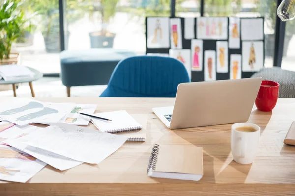 Lugar de trabajo de diseñador de moda con ordenador portátil y bocetos - foto de stock