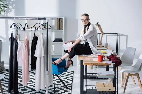 Atraente jovem designer de moda sentado na mesa de trabalho — Fotografia de Stock
