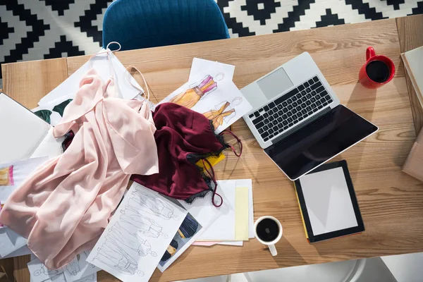 Vista superior del lugar de trabajo del diseñador de moda desordenado en la oficina - foto de stock