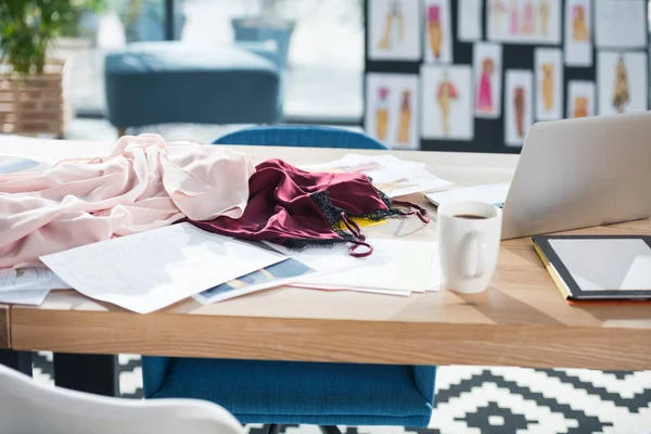 Lugar de trabajo de diseñador de moda desordenado en la oficina moderna - foto de stock