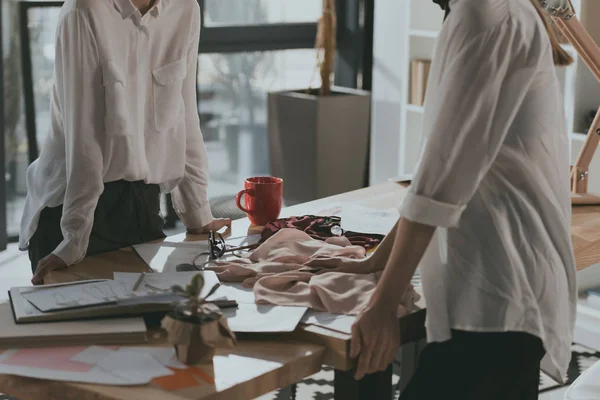 Recortado disparo de diseñadores de moda trabajando juntos en la oficina — Stock Photo