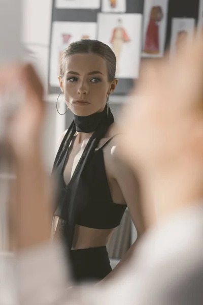 Atractiva mujer joven con ropa elegante mirando hacia otro lado - foto de stock