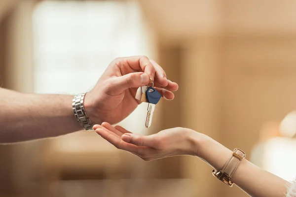 Обрезанный снимок агента по недвижимости, передающего ключ клиенту — стоковое фото