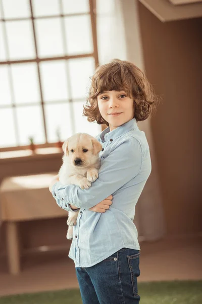 Little kid holding his adorable labrador puppy — Stock Photo