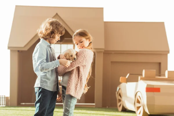 Entzückende kleine Kinder streicheln kleine Labrador Welpen isoliert auf weiß — Stockfoto