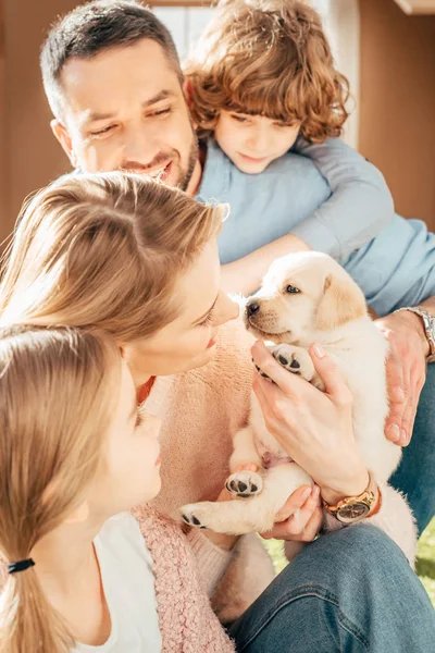 Jovem família feliz com adorável filhote de cachorro labrador — Fotografia de Stock