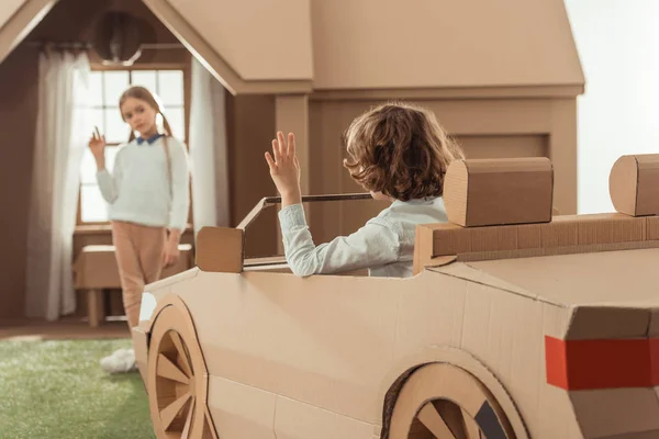 Little kid arrived for girlfriend on cardboard car — Stock Photo