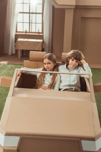 Adorable kids couple riding cardboard car — Stock Photo