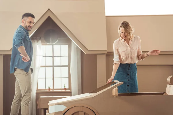 Man presenting cardboard car to his girlfriend for birthday — Stock Photo