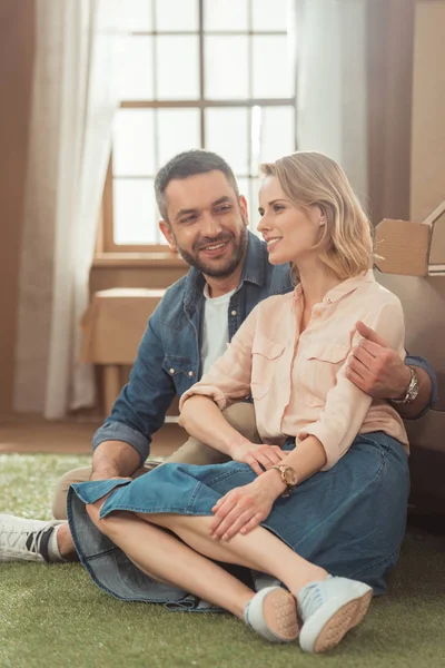 Couple relaxing on yard of cardboard house — Stock Photo