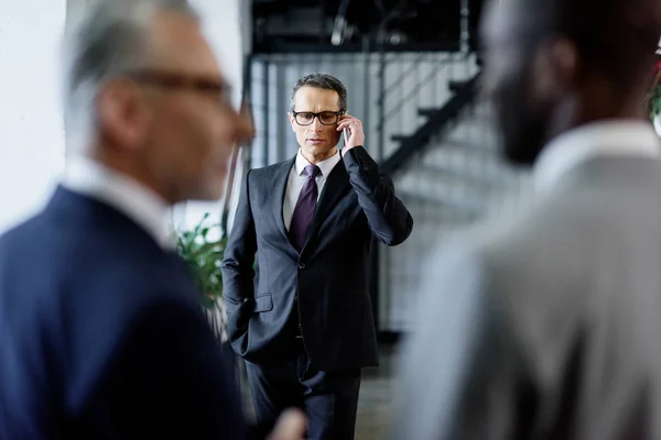 Selective focus of businessman talking on smartphone in office — Stock Photo