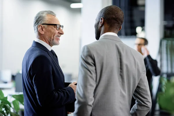 Selective focus of multicultural businessmen having conversation in office — Stock Photo