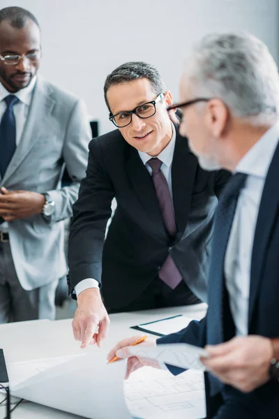 Selective focus of multicultural businessman discussing new strategy in office — Stock Photo
