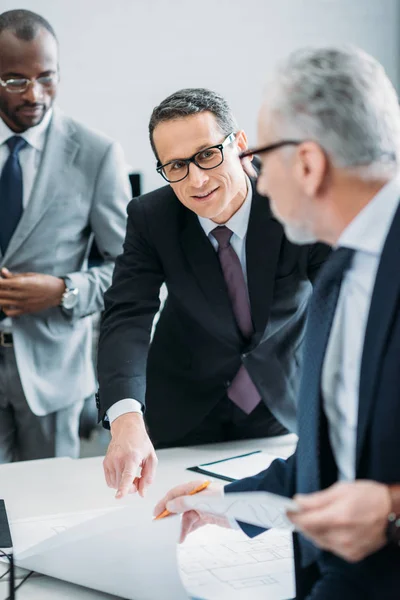 Enfoque selectivo del hombre de negocios multicultural discutiendo nueva estrategia en el cargo - foto de stock